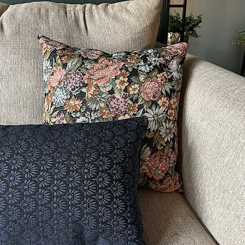 two french throw pillows on couch, one blue lumbar, the other pillow a square floral design